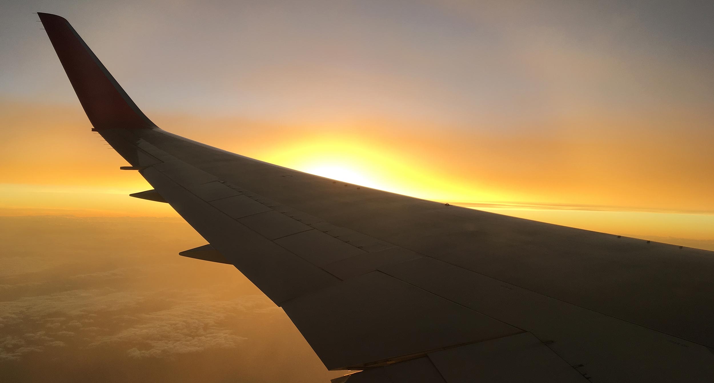 Airplane wing as the sun rises