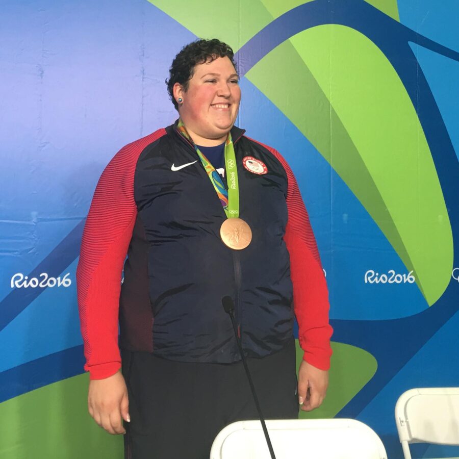 A U.S. weightlifter smiles with her bronze medal