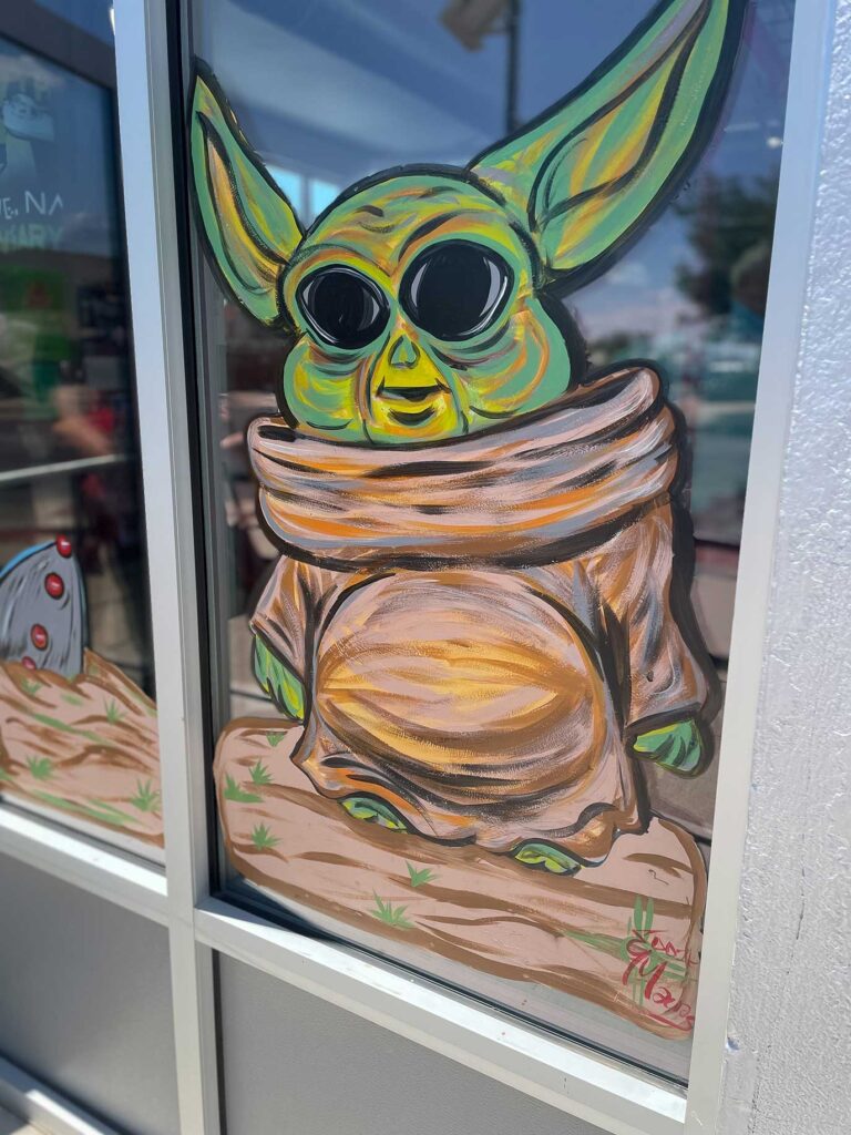A window drawing of baby Yoda from Star Wars