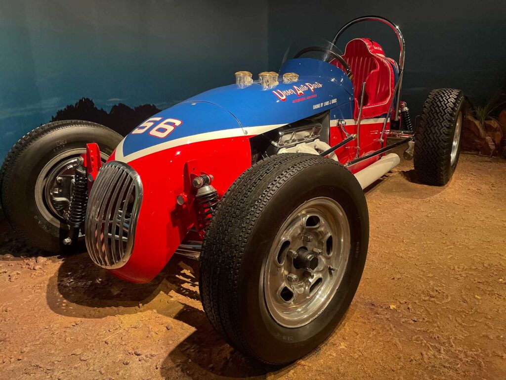A red and blue open wheel race car in a museum