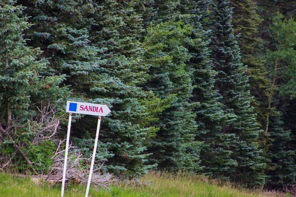 A sign reading "Sandia" in the forest