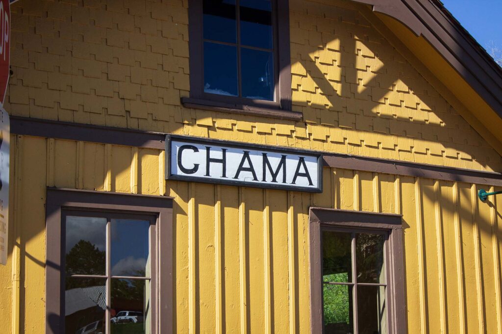 A yellow station building with a sign reading "Chama"
