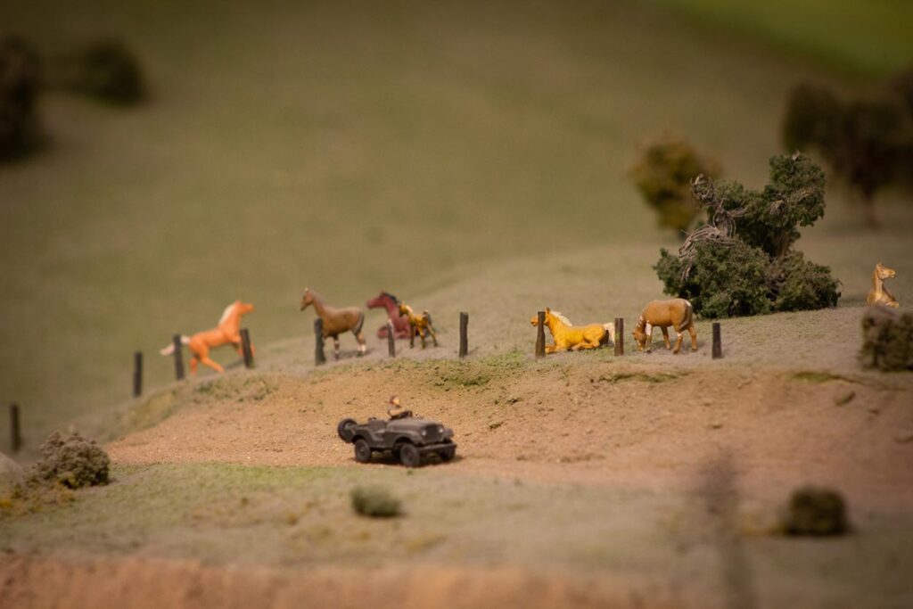 Small horses roaming on a model train layout