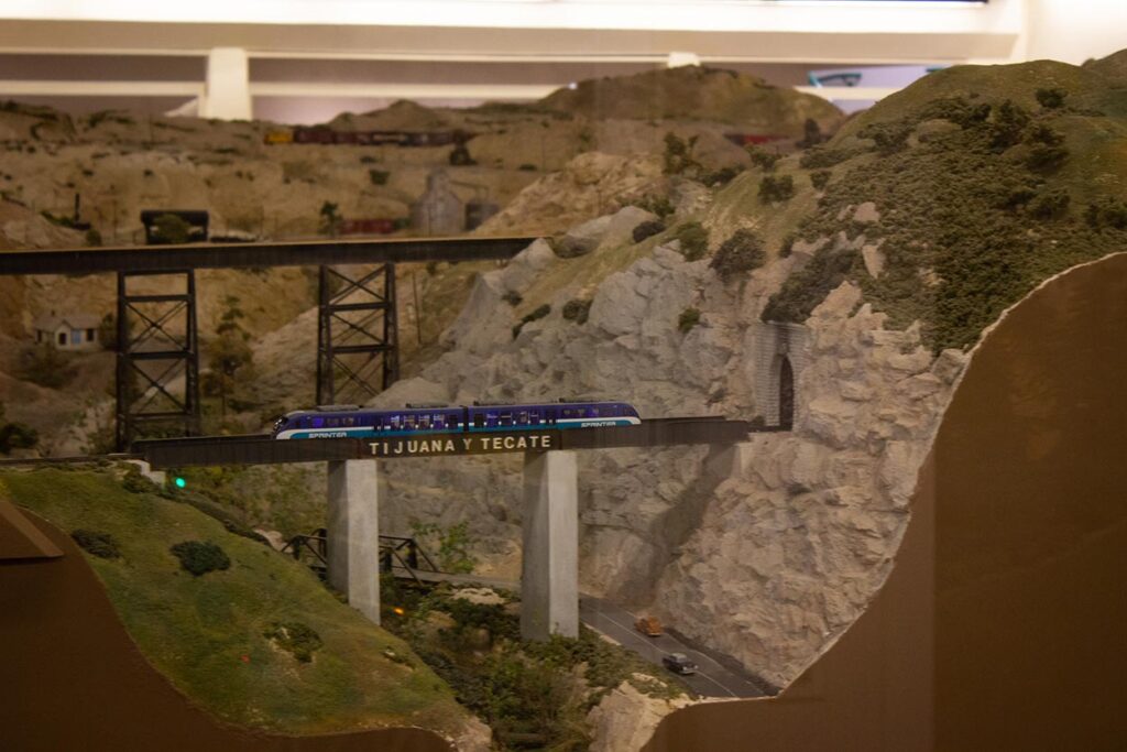 A San Diego Coaster model train on a birdge on a model train layout
