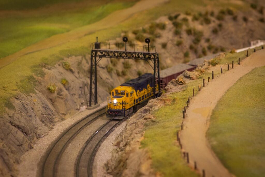 A blue and yellow Santa Fe train climbing a spiral grade on a model train layout