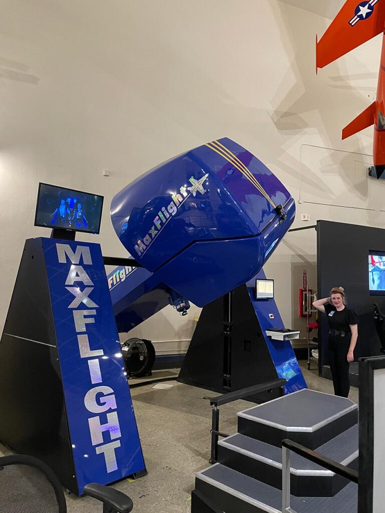 A blue flight simulator machine in a museum