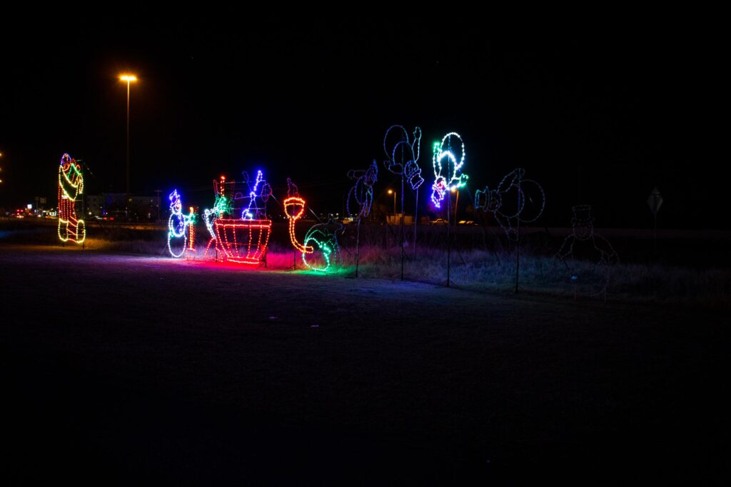 Colored lights in a park at night depicting a snowman flipping over