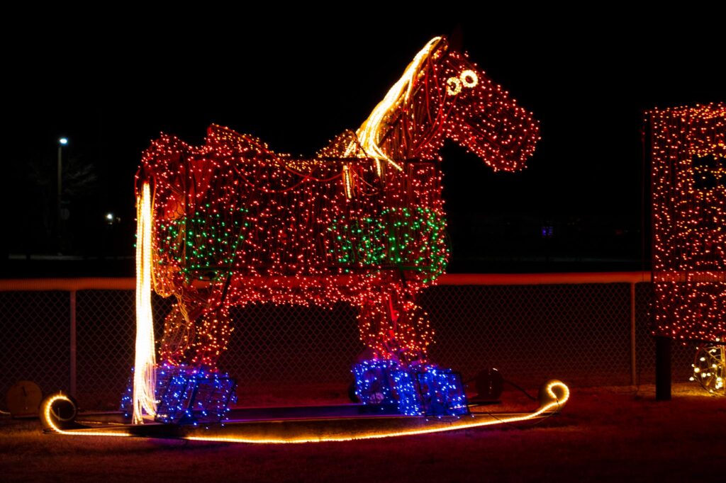 Colored lights in a park at night depicting a rocking horse