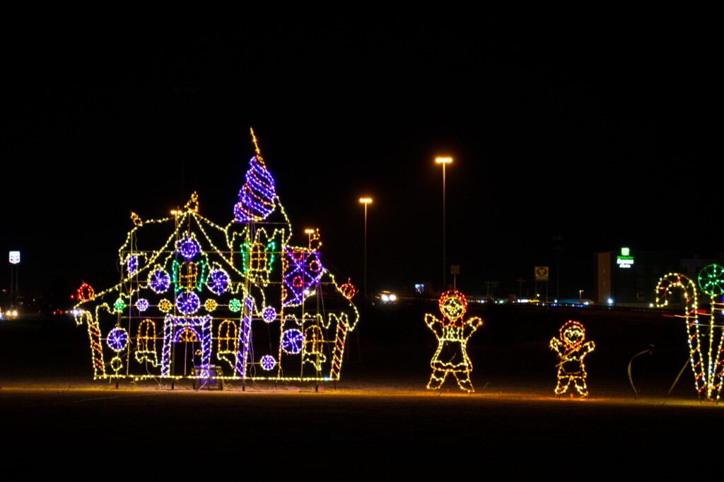Colored lights in a park at night depicting a gingerbread house