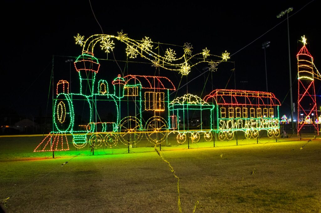 Colored lights in a park at night depicting a train