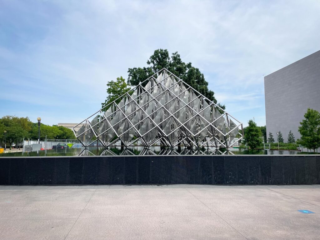 A sculpture made up of metal cubes stacked like a pyramid