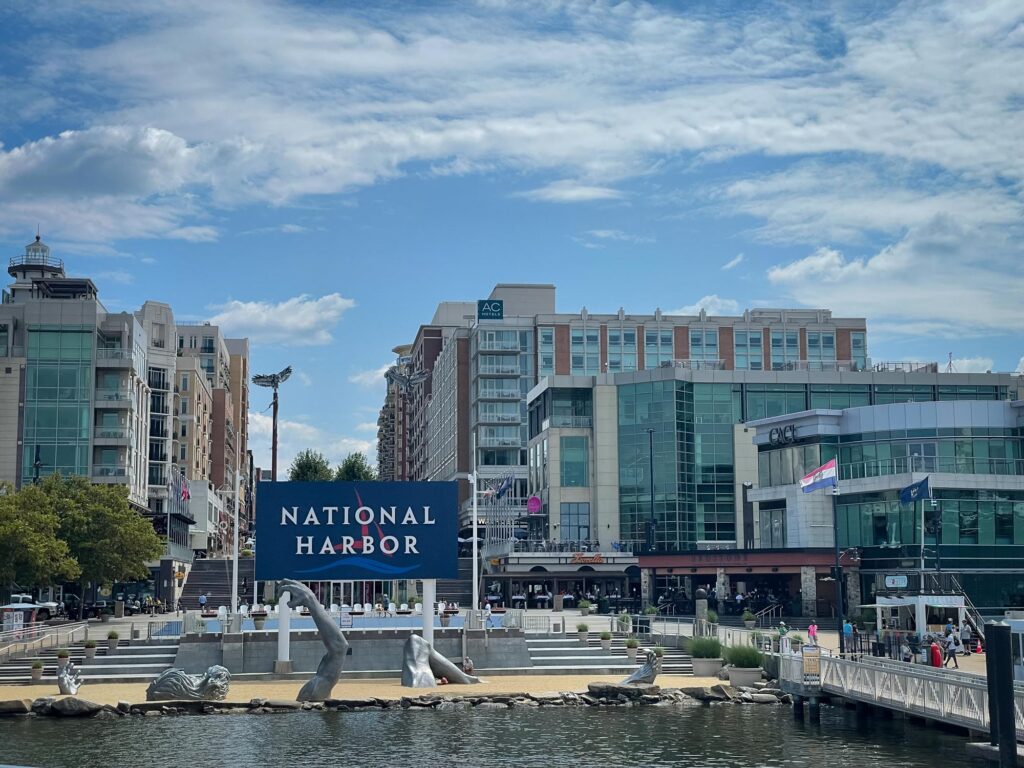 Buildings at the water with a sign that says "National Harbor"