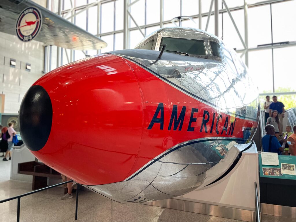 The front part of an old American Airlines silver and red orange plane