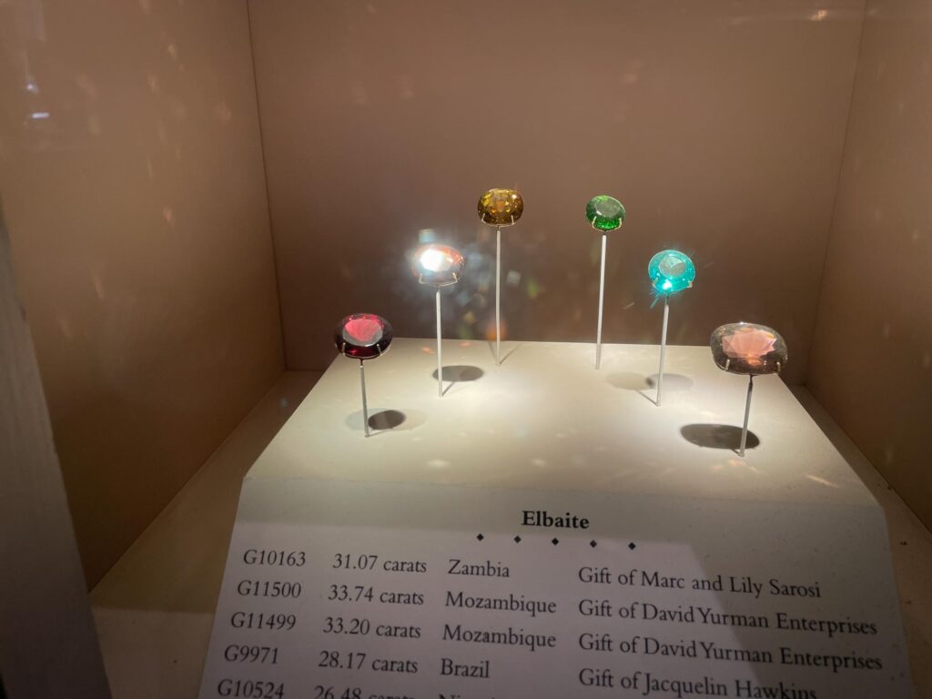 Elbaite gemstones in a glass case in a museum exhibit
