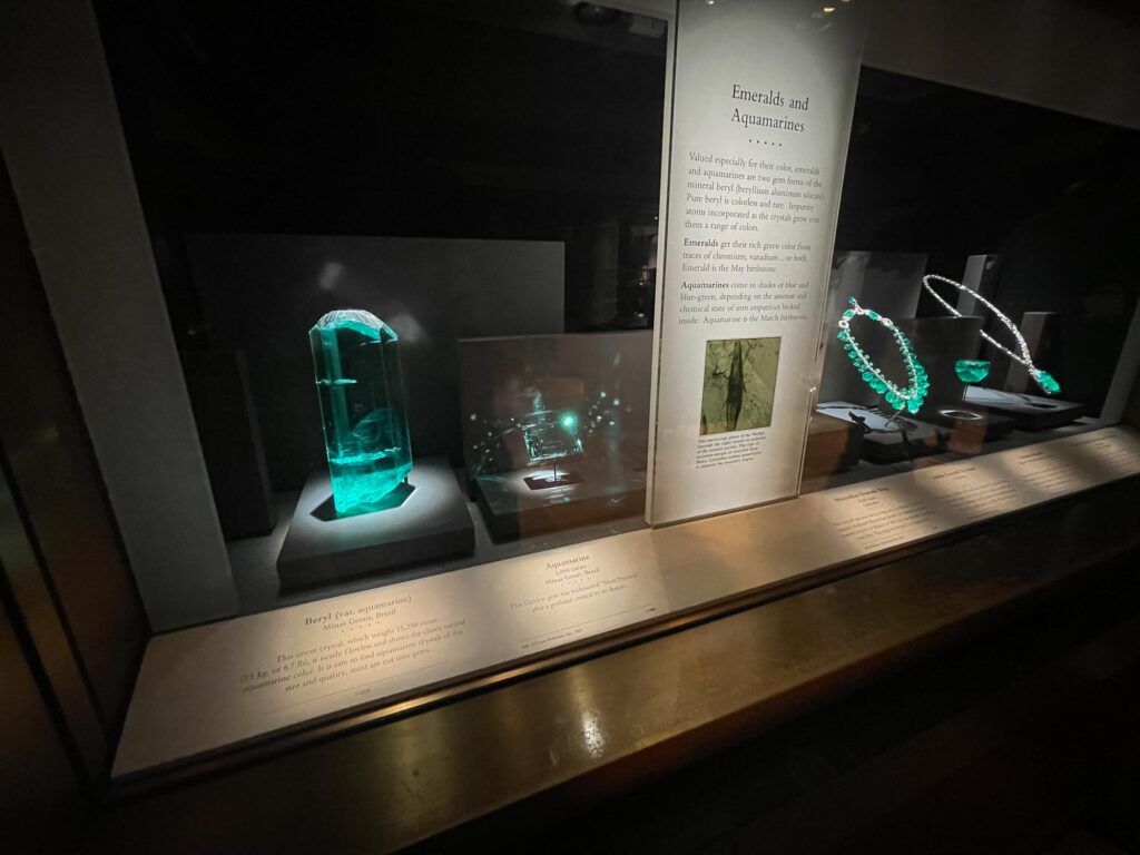 Emerald and aquamarine diamonds in a glass case in a museum exhibit
