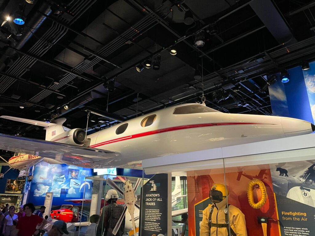 A white private jet plane hanging in a museum