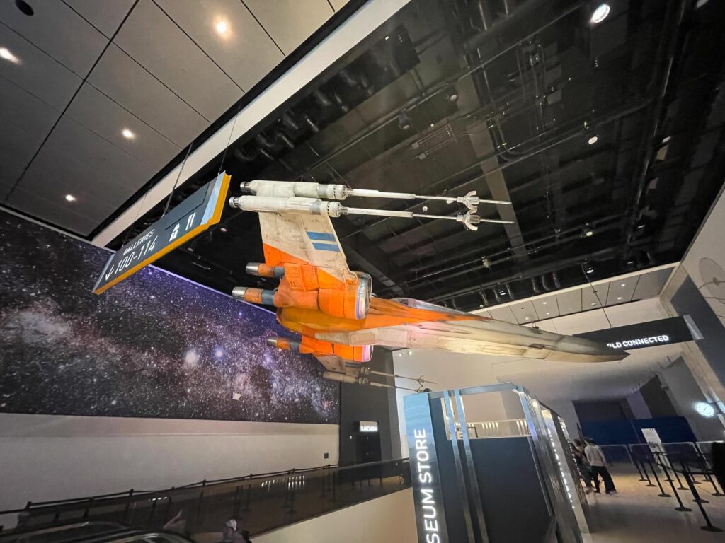 An X-wing aircraft hanging in a museum