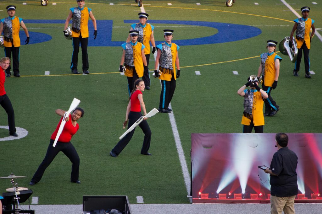 A drum corps performing in yellow, blue and silver uniforms