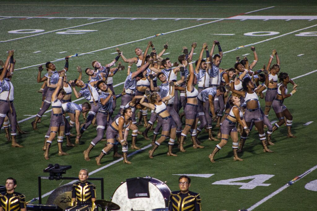 A drum corps colorguard performing on the field