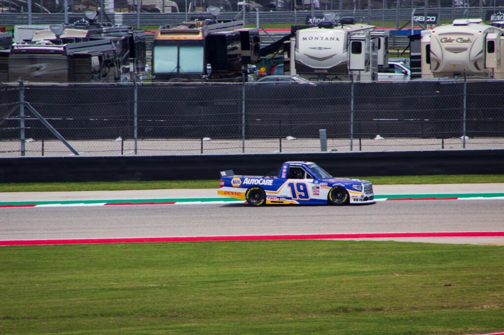 A blue, white and gold race truck on a race track