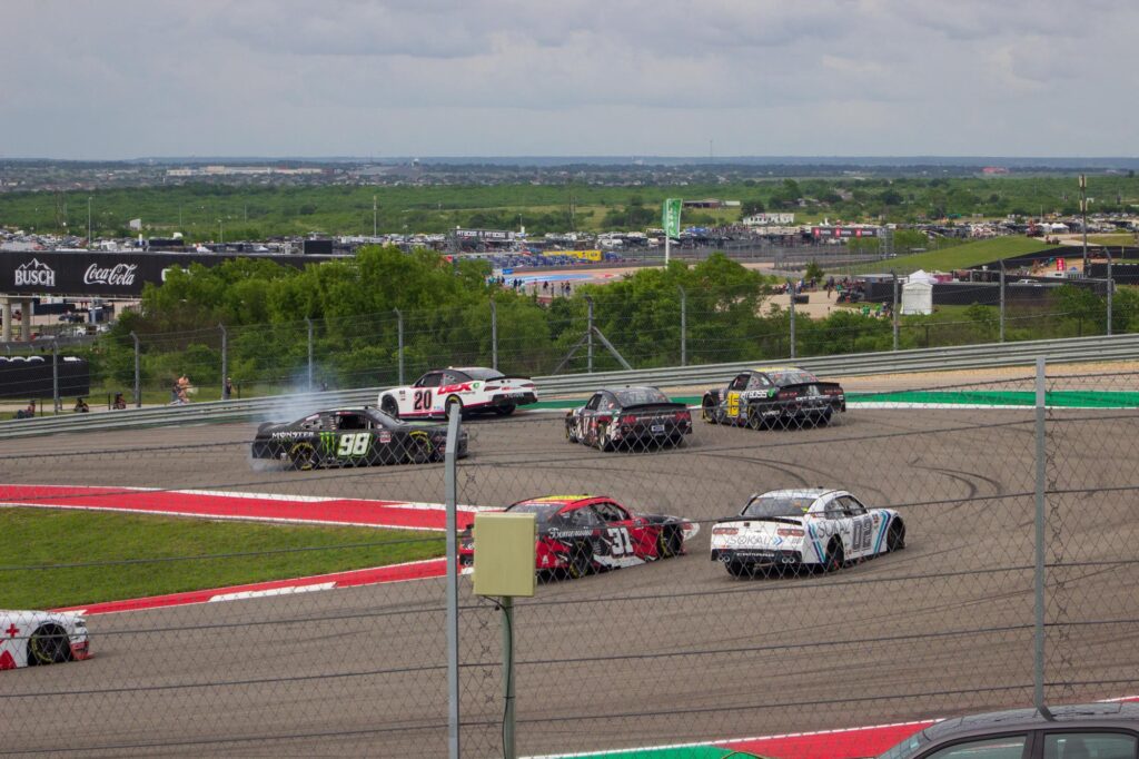 A car spinning in front of other cars in a race on a racetrack