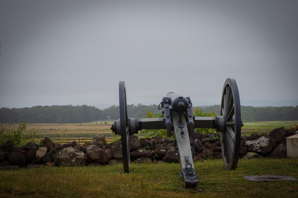 A replica civil war cannon facing an open field