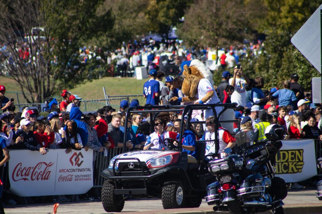 A horse mascot for the Texas Rangers riding in a parade on a four wheeler