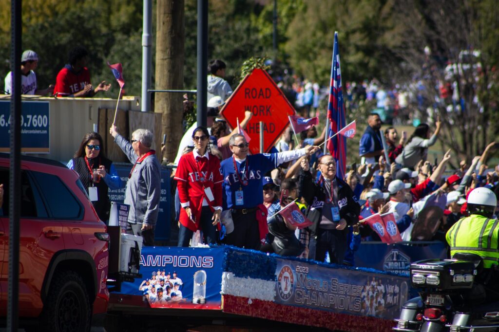 People in Texas Rangers jerseys and jackets on a float in a parade