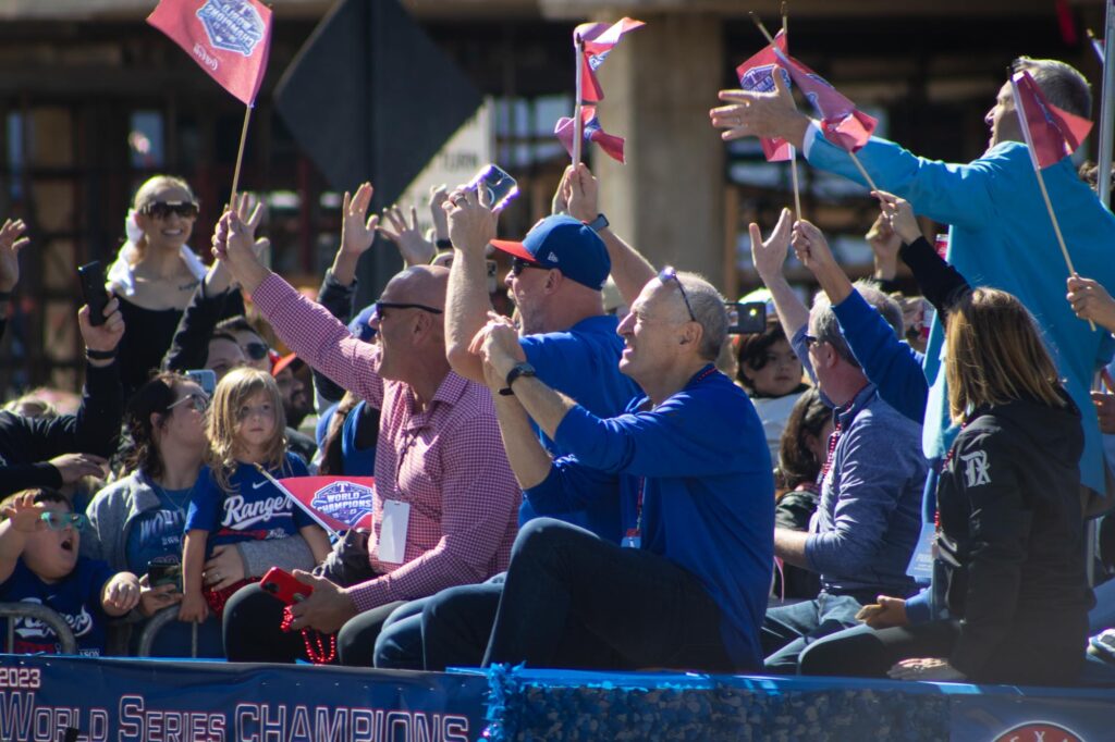 People in Texas Rangers jerseys and jackets on a float in a parade